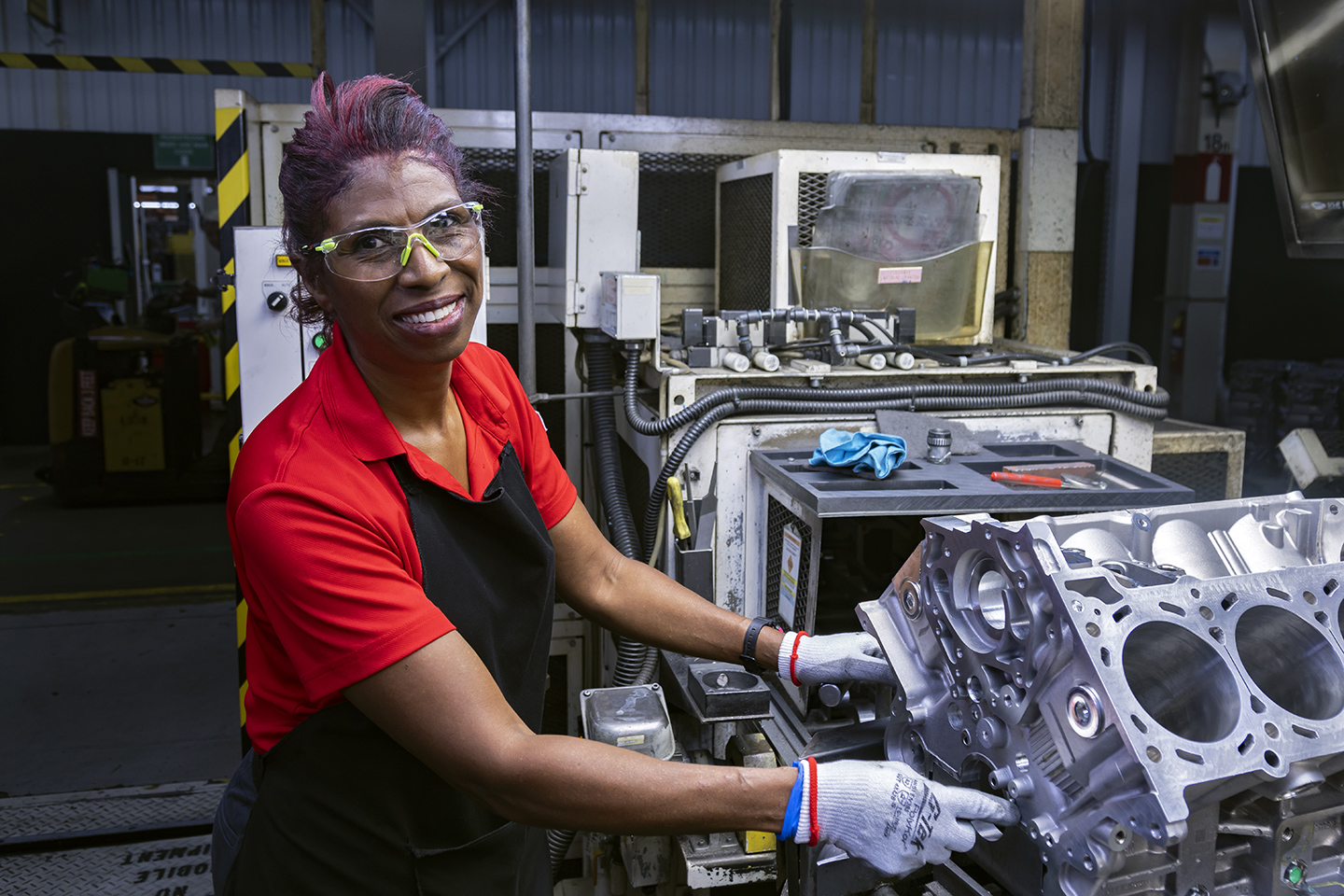 Joyful Nissan technician assembling vehicle components