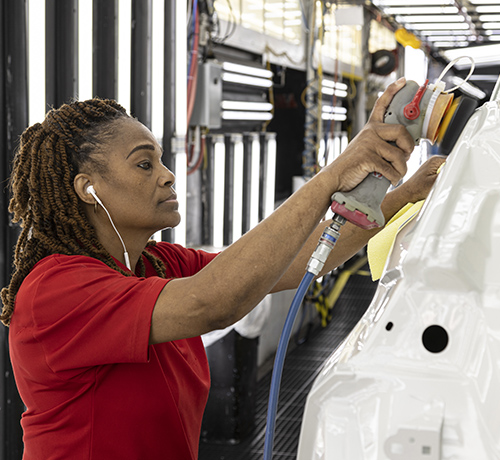 Nissan worker buffing and polishing car exterior